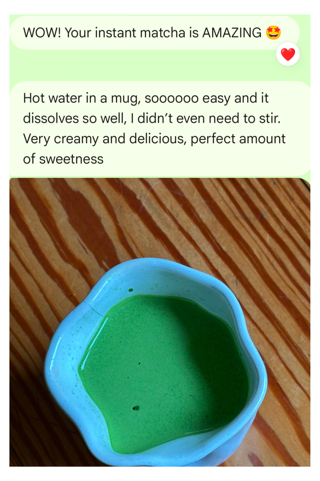Green matcha in a blue mug on a wooden surface with text praising the matcha's quality.